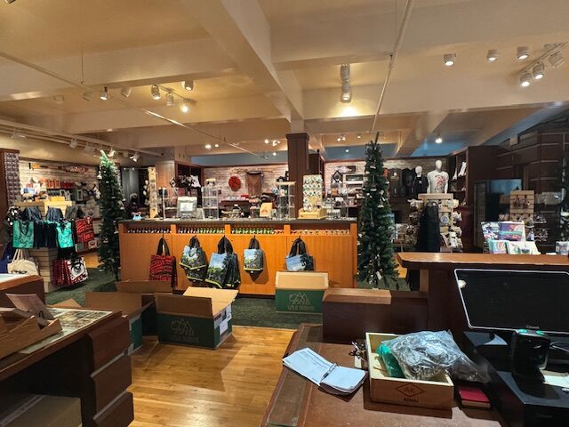 Interior of a store with wooden floorboards and a fake lawn in the center